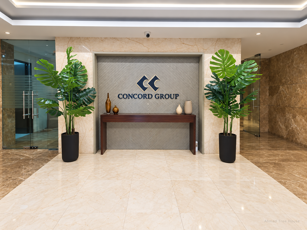 Tropical plants framing the Concord Group reception desk — Ahmad Tree House project