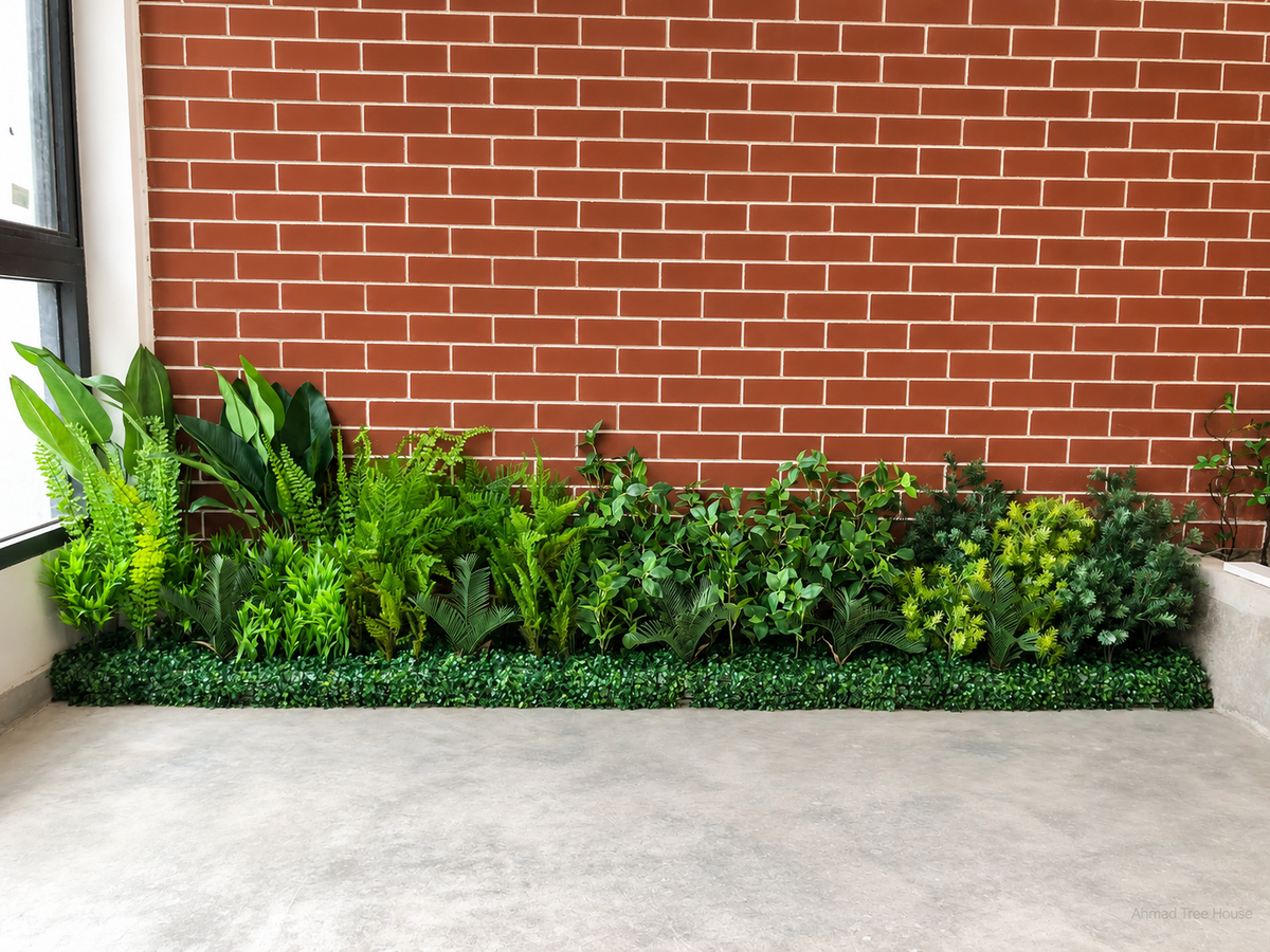 Low mixed foliage border against a brick feature wall — Ahmad Tree House project