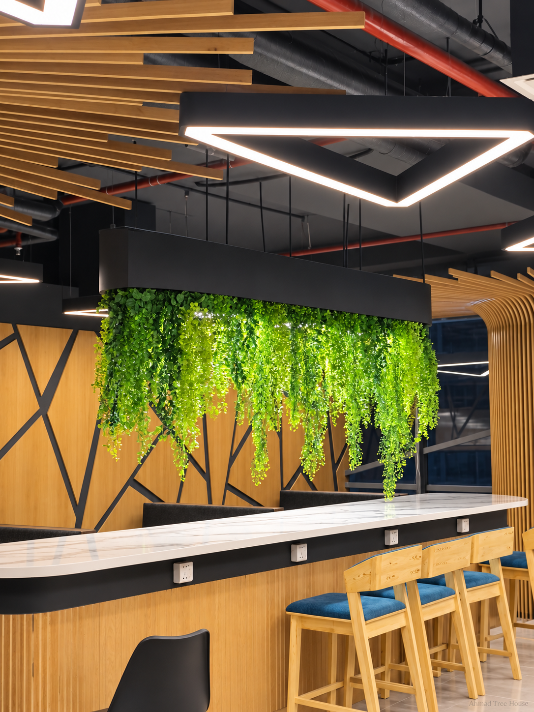 Hanging greenery over a bar counter with a slatted ceiling — Ahmad Tree House project