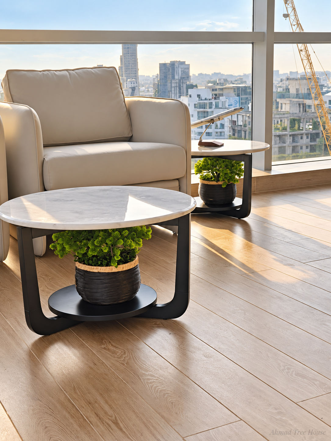 Small potted trees arranged beneath office lounge tables — Ahmad Tree House project