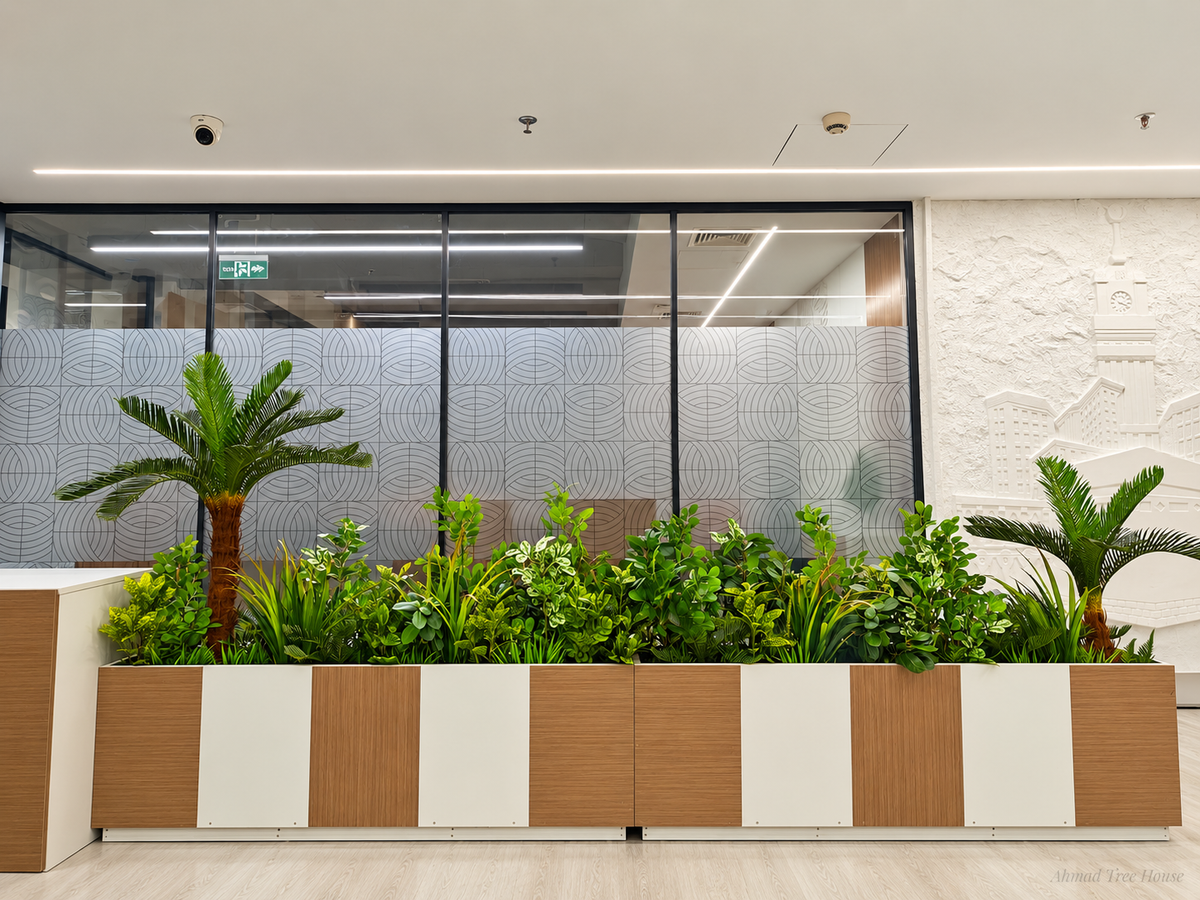 Mixed office greenery in a long white and wood planter — Ahmad Tree House project