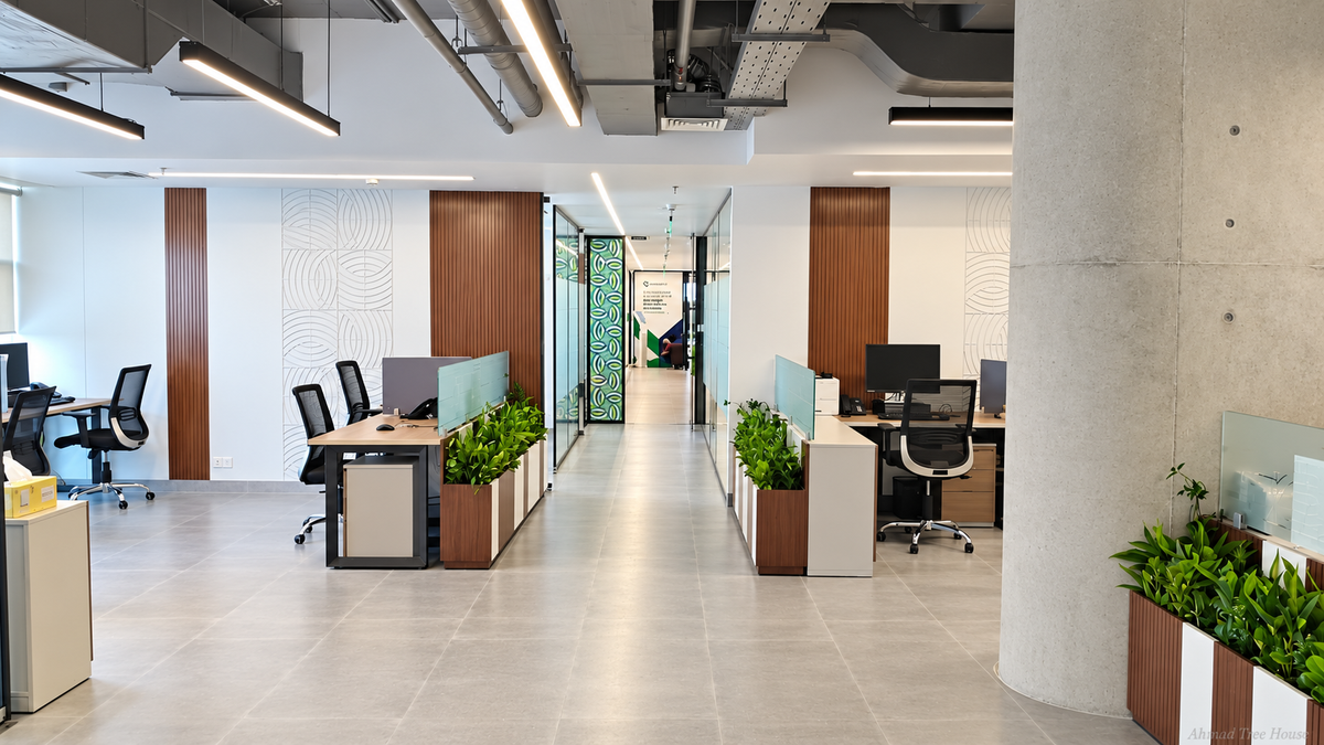 Open office workspace with greenery along desk partitions — Ahmad Tree House project