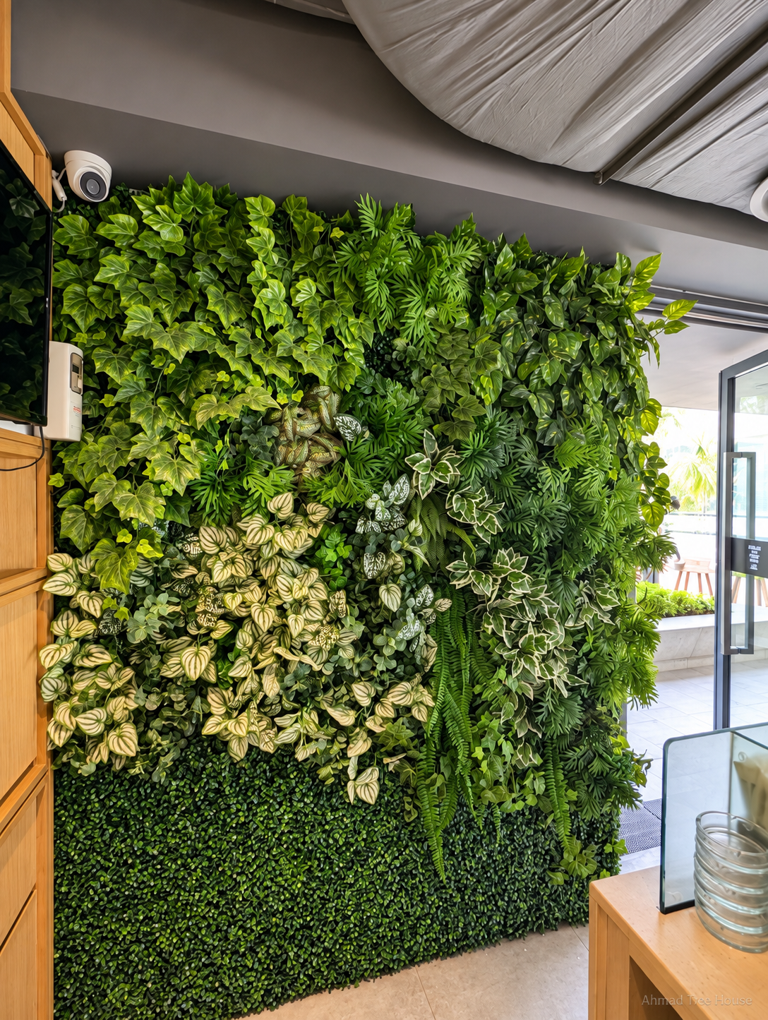 The White Canary Café mixed-leaf green wall from the side — Ahmad Tree House project