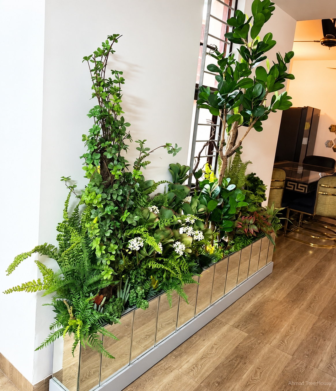 Mirrored planter with mixed foliage and tall trees in a home — Ahmad Tree House project