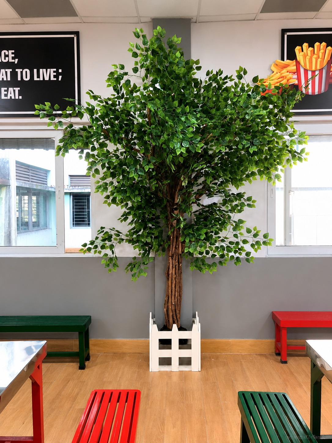 Green restaurant tree with a white picket planter border — Ahmad Tree House project